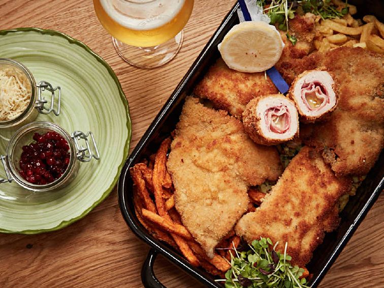 : allerlei Schitzel mit unterschiedlichen Pommes, Beilagen und einem Bier Schnitzelreindl im Gasthaus DER BIERMANN München